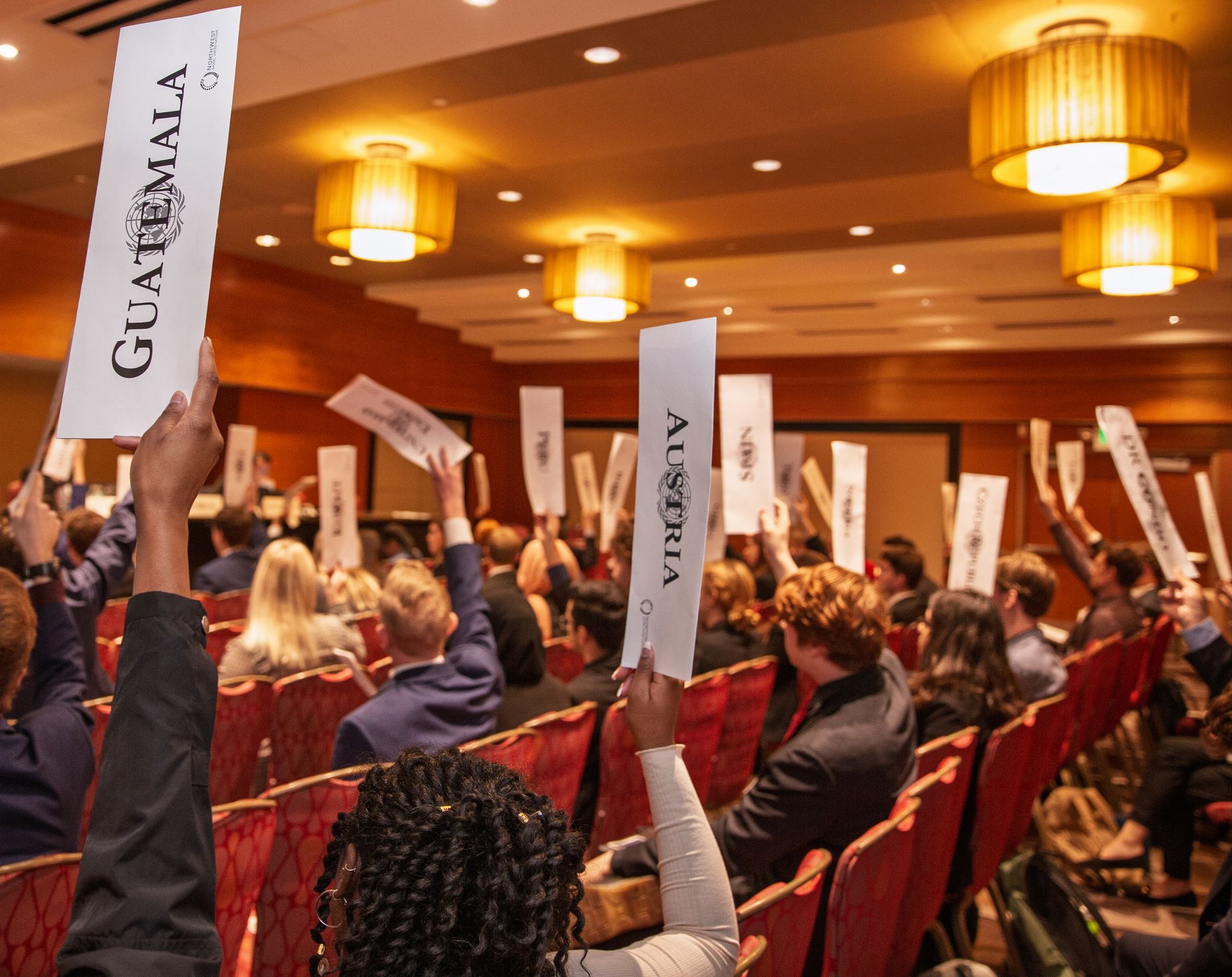 Delegates raising country placards during a NWMUN conference session
